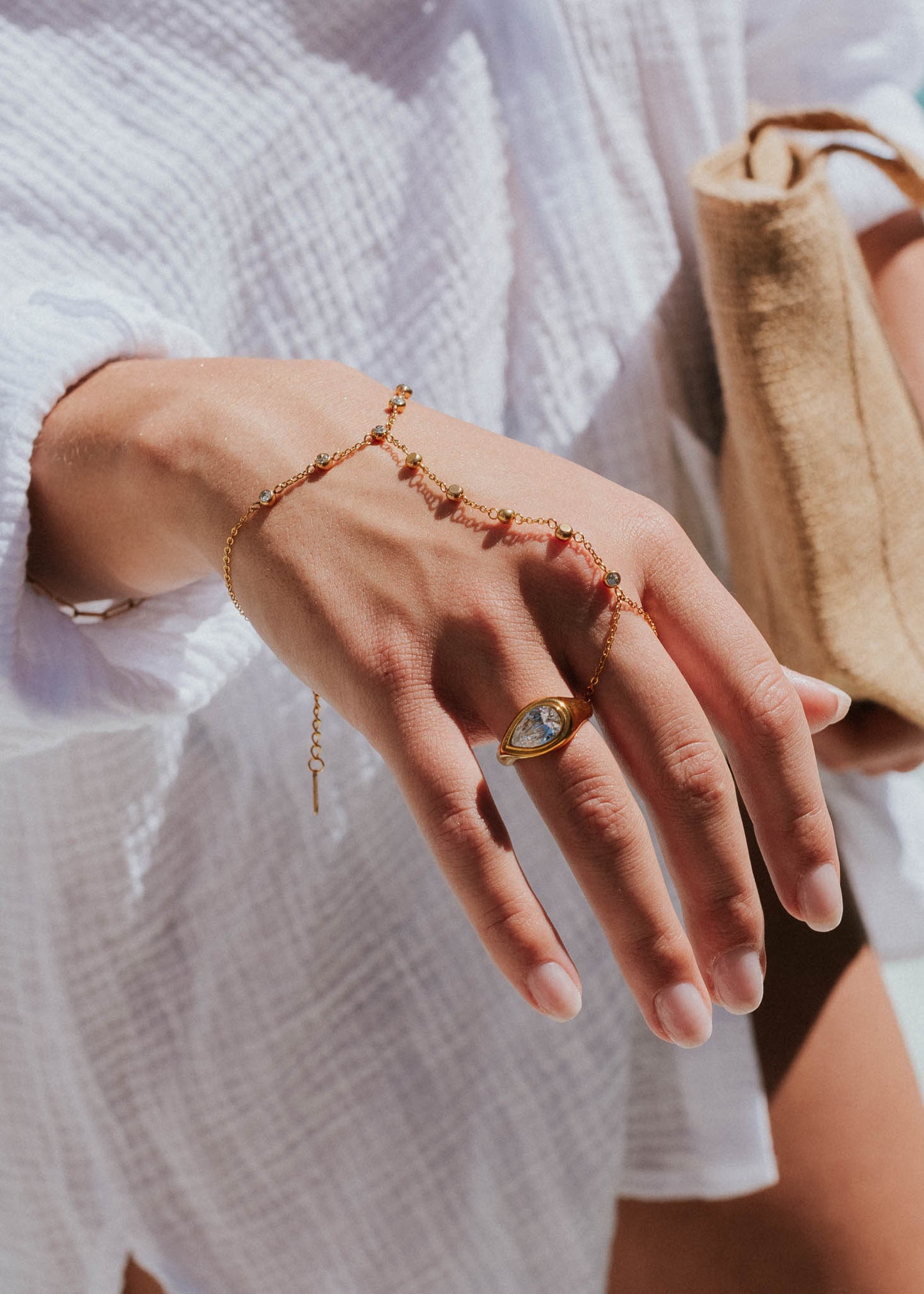 Close-up of a hand wearing gold jewelry with a blurred background