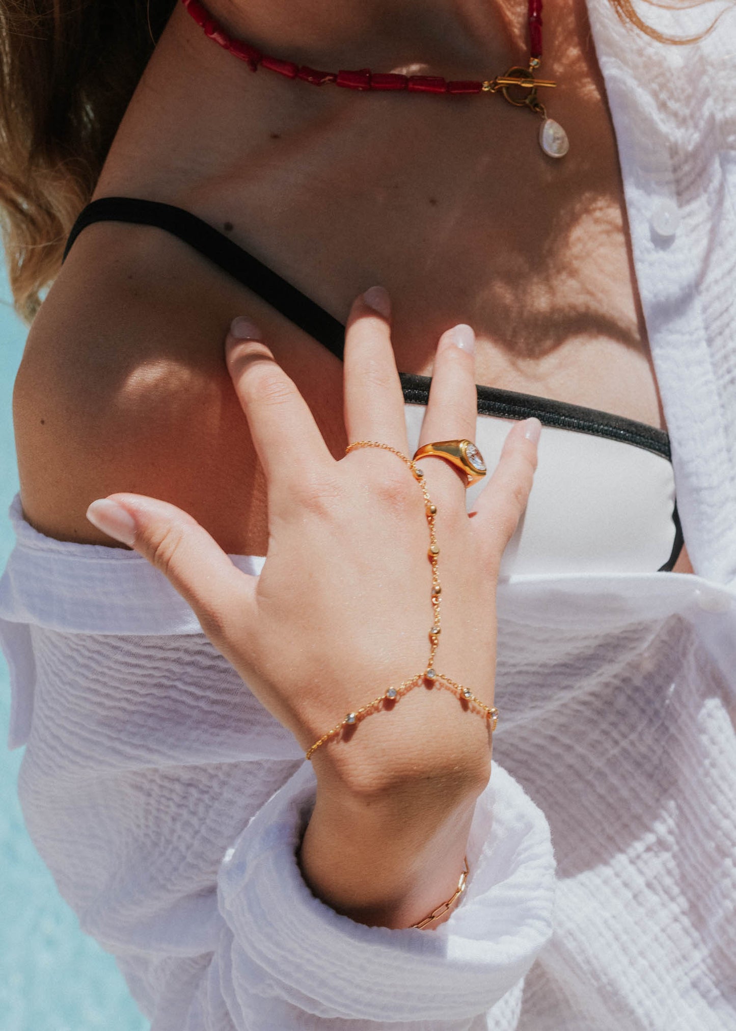 Close-up of a hand with jewelry by a poolside