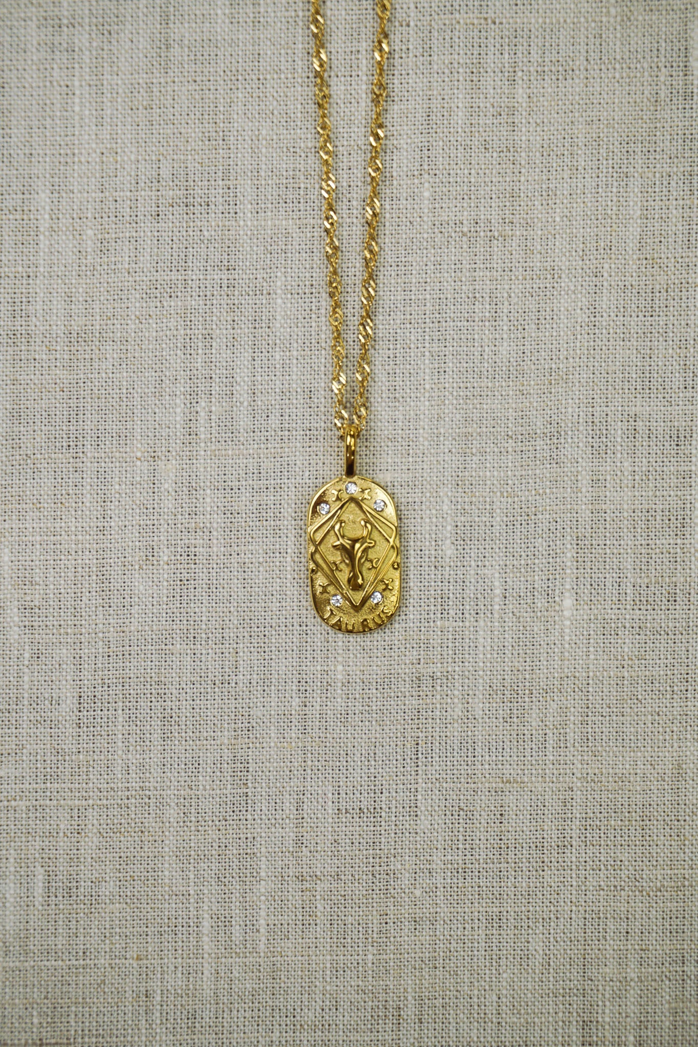 Gold thin dainty necklace with a taurus zodiac pendant