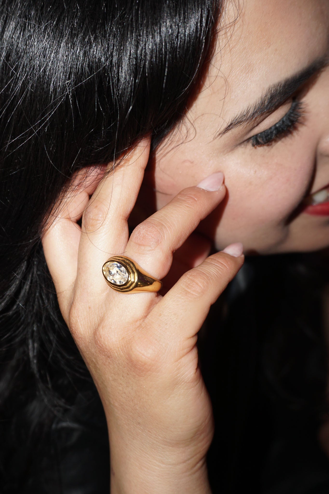 Close-up of a hand with a gold ring on a dark background