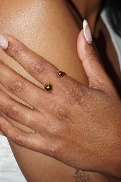 Close-up of a hand with gold beads on a blurred background