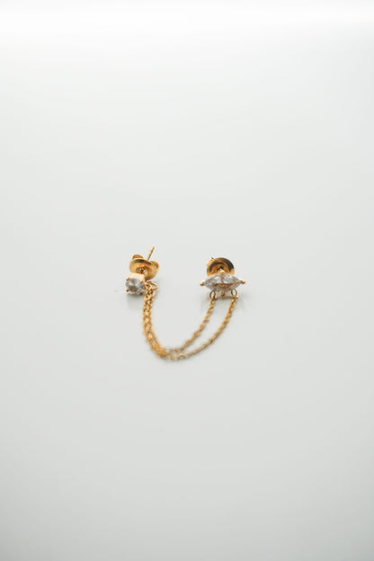 Gold chain earrings on a light gray background