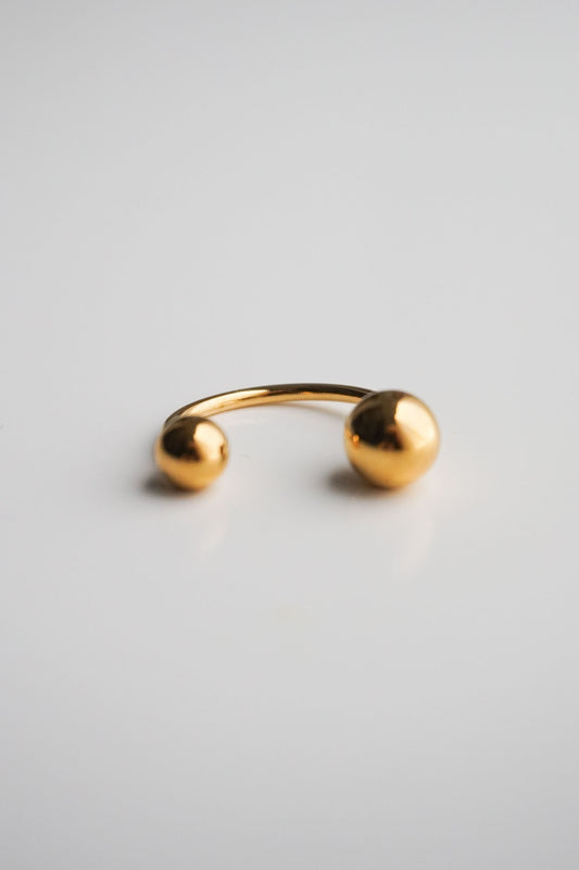 Gold open ring on a light gray background