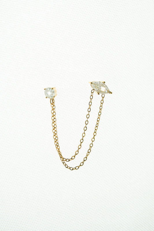 Gold chain earrings with clear gemstones on a white background
