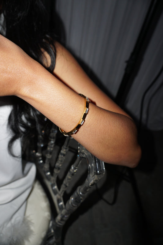 Close-up of a person's ankle with a bracelet on a dark background